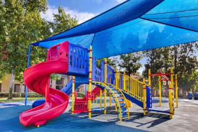 a colorful playground with a slide and umbrella Brightly colored playground with slides and shade coverings  at Citrine Hills, California, 91761