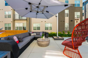 a patio with a couch and chairs and an umbrella at Mockingbird Flats, Dallas, TX, 75206