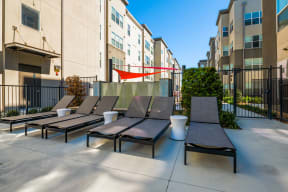 a group of lounge chairs in front of an apartment building at Mockingbird Flats, Texas