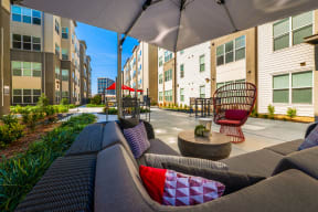 a patio with couches and chairs in front of an apartment building at Mockingbird Flats, Texas, 75206