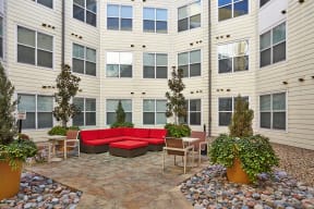 an outdoor area with a couch and tables in an apartment building at Mockingbird Flats, Dallas, 75206