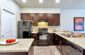 a kitchen with dark wood cabinets and granite countertops at Allora Phoenix Apartments, Phoenix, AZ