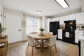 A modern kitchen with a dining table set for two.