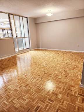A room with wooden flooring and a window.