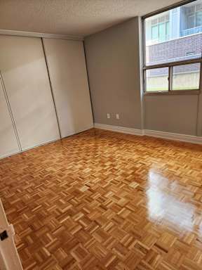A room with wooden flooring and a window.