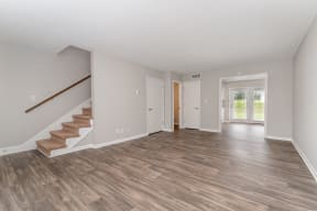 a living room with hardwood floors and a staircase