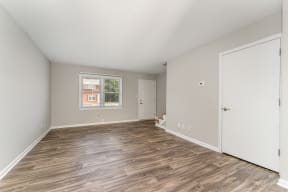 a bedroom with hardwood floors and grey walls