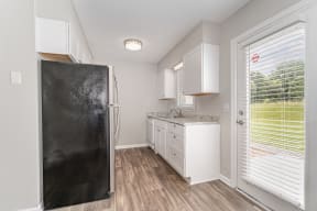 a kitchen with white cabinets and a black refrigerator