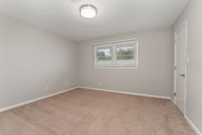 a bedroom with a carpeted floor and a window