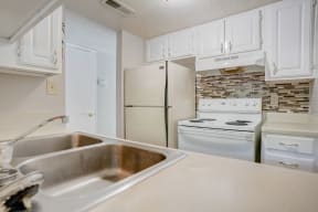 a kitchen with white appliances and white cabinets