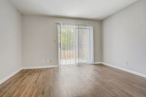 a bedroom with a sliding glass door and hardwood floors