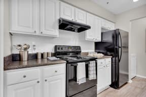 a kitchen with stainless steel appliances and white cabinets at Madison Brookhaven, Georgia, 30329