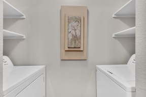 a laundry room with two machines and a painting on the wall at Madison Brookhaven, Georgia