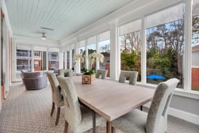 a dining room with a wooden table and chairs and large windows at Madison Brookhaven, Atlanta