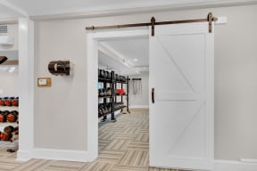 a white sliding barn door opens to a closet with shoe racks at Madison Brookhaven, Georgia, 30329
