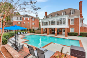 a swimming pool with chairs and a house in the background at Madison Brookhaven, Georgia