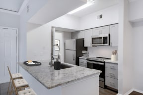 a kitchen with white cabinets and a granite counter top