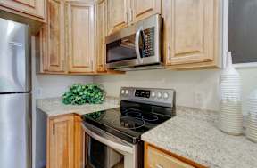 A kitchen with a stove, oven, microwave, and refrigerator.