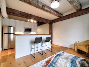 A kitchen with a white counter and a fridge.