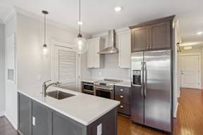 A modern kitchen with a stainless steel refrigerator and a sink with a faucet.