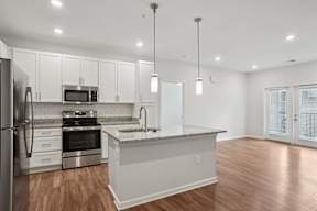 A modern kitchen with stainless steel appliances and white cabinets.
