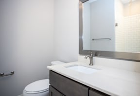 A white toilet sits next to a sink in a bathroom.