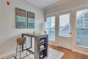 A dining table with a chair and a shelf with a plant on it.