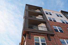A red brick building with a balcony on the second floor.