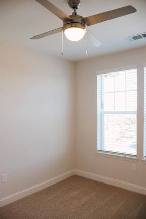 A room with a ceiling fan and a window.