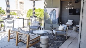 a living room with couches and chairs and a large screen tv on the wall at The Fitzgerald, Spartanburg, SC