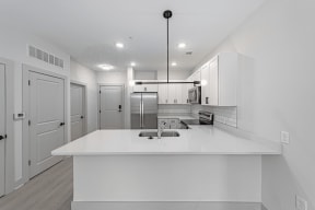 a kitchen with white cabinets and a white counter top at The Fitzgerald, Spartanburg, SC