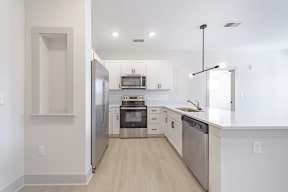 a kitchen with white cabinets and stainless steel appliances at The Fitzgerald, Spartanburg, 29302