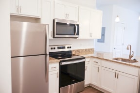 a kitchen with stainless steel appliances and white cabinets