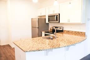 A kitchen with granite countertops and stainless steel appliances.