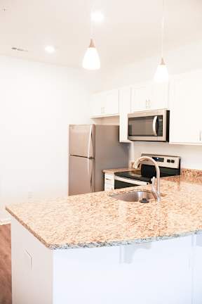 A kitchen with granite countertops and white cabinets.