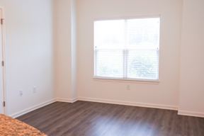 A room with a window and wooden flooring.