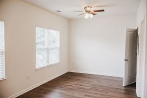an empty room with a ceiling fan and a door