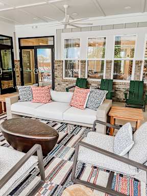 A living room with a white couch, a wooden coffee table, and a rug with a pattern.