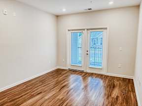 A room with a wooden floor and a sliding glass door.