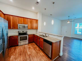 an empty kitchen with wooden cabinets and stainless steel appliances