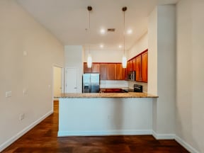 an empty living room with a kitchen and a counter top