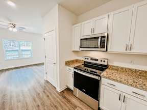A kitchen with a microwave on top of the stove.