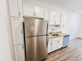 a kitchen with white cabinets and a stainless steel refrigerator