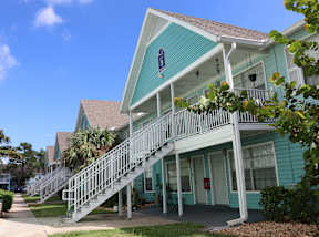 A blue house with a white staircase leading to the front door.