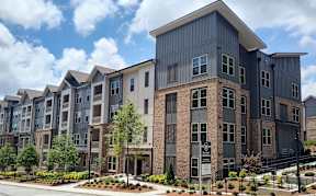 A large, modern apartment complex with a variety of windows and balconies.