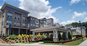 A large, modern building with a landscaped front yard.