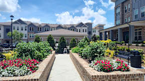 A row of houses with a garden in front.