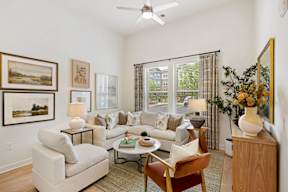 A living room with a white couch, a coffee table, and a painting on the wall.