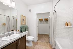 A white bathroom with a toilet, sink, and shower.