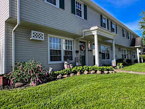 the front of a townhouse with landscaping on the yard